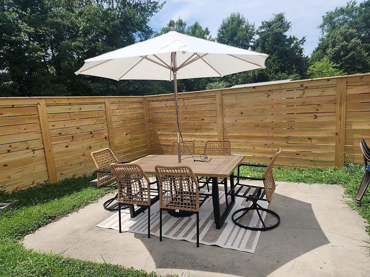 Horizontal wood privacy fence installed around backyard patio seating area in Hampton Roads VA