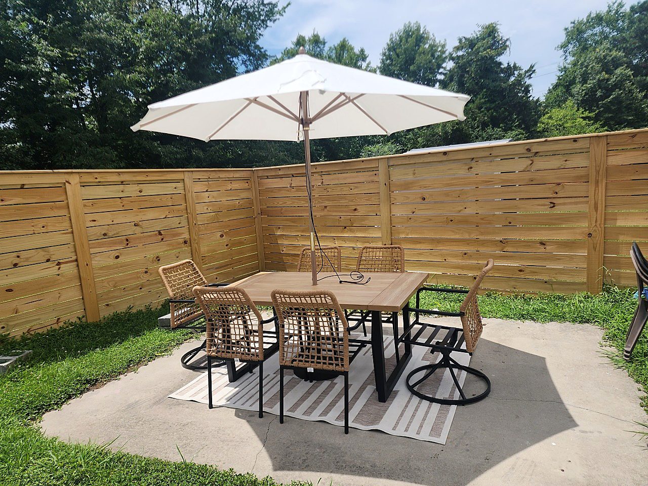 Horizontal wood privacy fence installed around backyard patio seating area in Hampton Roads VA