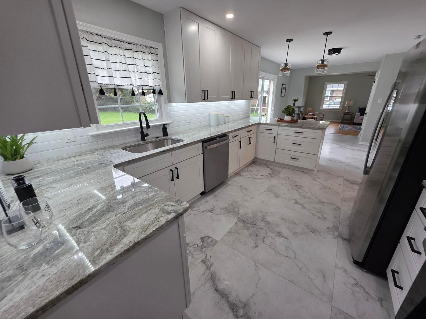 Bright remodeled kitchen with white cabinetry, granite counters, and subway tile backsplash in a Hampton Roads home.