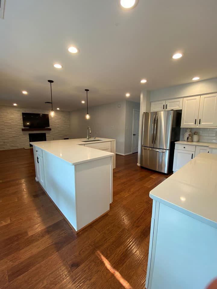 Open-concept kitchen renovation after photo with quartz island and hardwood floors