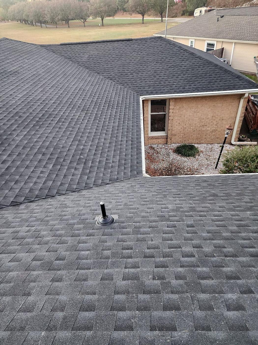 Roof replacement with dark architectural shingles viewed from above across multiple roof planes